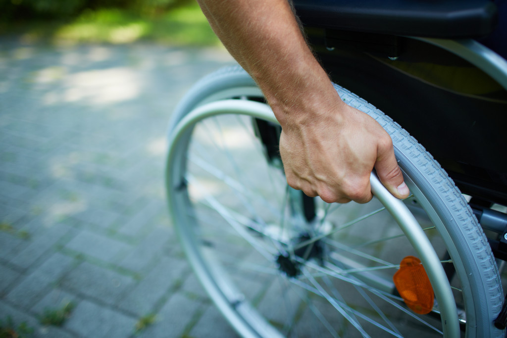 An image of a man's hand on wheelchair wheel